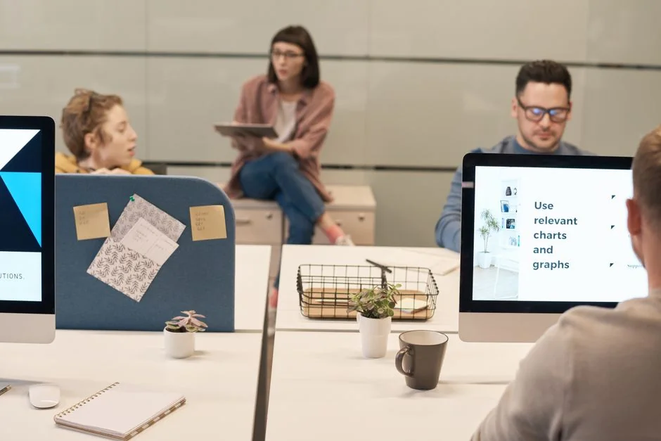 A contemporary workspace with dual computer monitors presenting web design projects, underscoring technology and productivity.